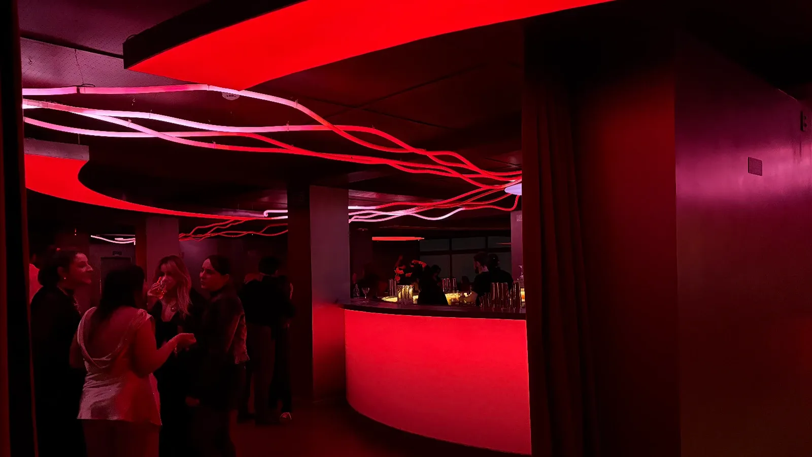 Ambiente interno do Iccarus Bar, luzes vermelhas e envolventes