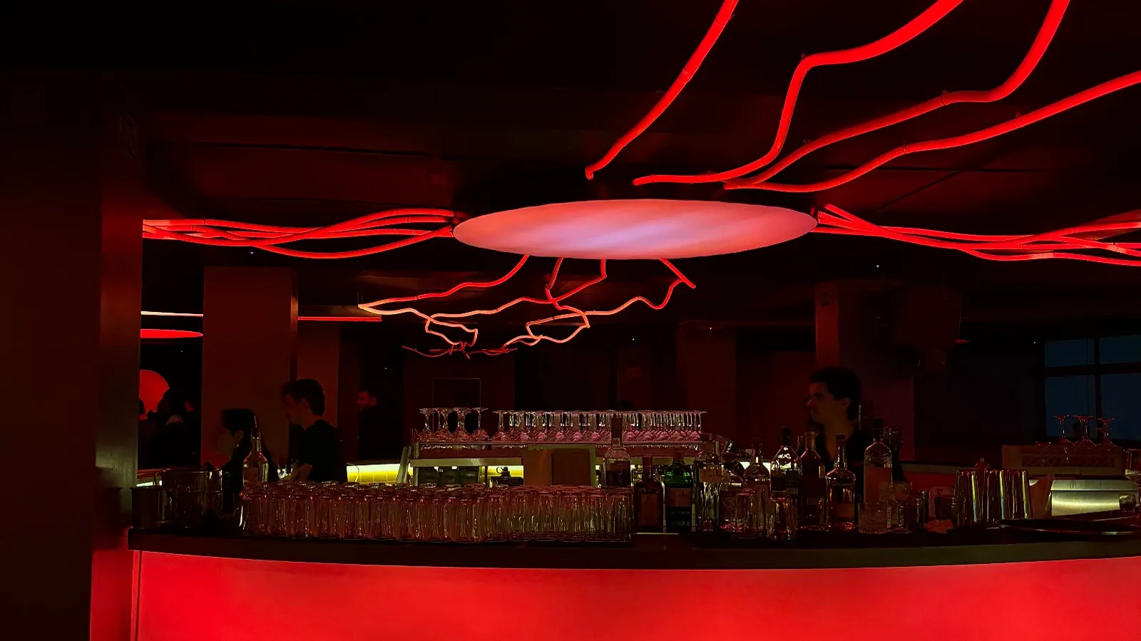 Ambiente interno do Iccarus Bar, luzes vermelhas modernas no teto